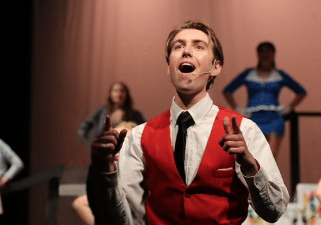 Male character singing on stage